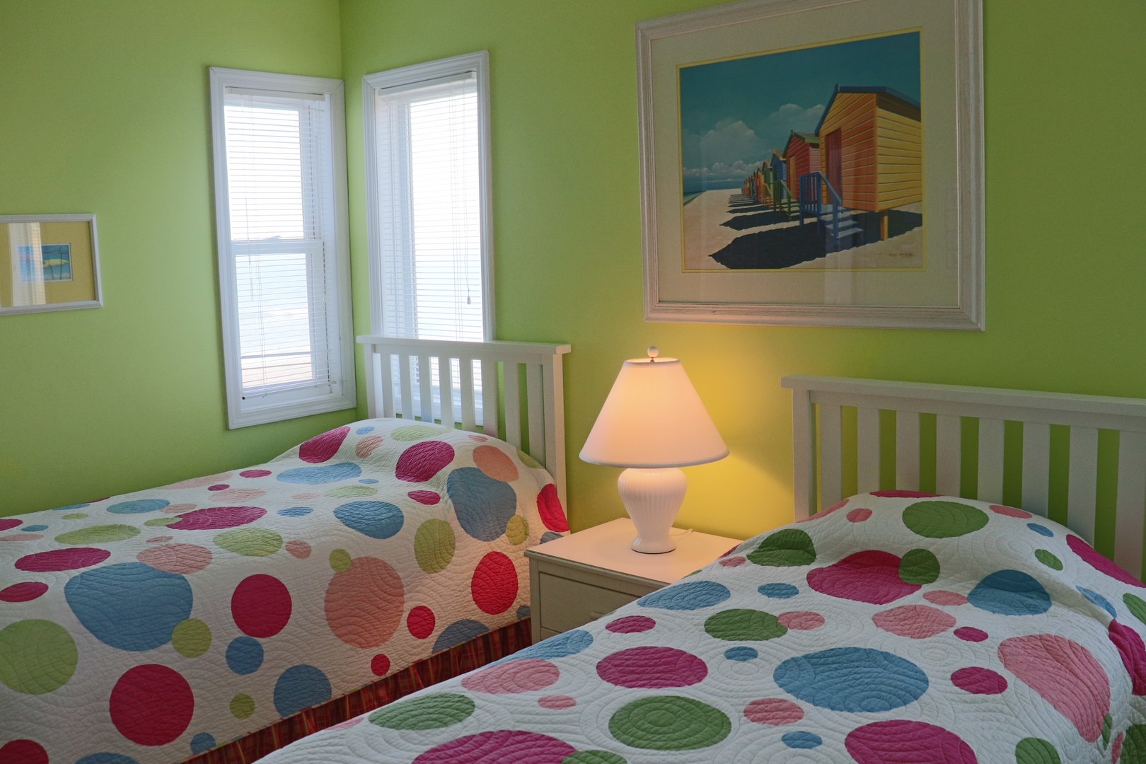 Drift off in this cheerful twin bedroom where colorful polka-dot bedding and beach-themed art create a playful coastal vibe.
