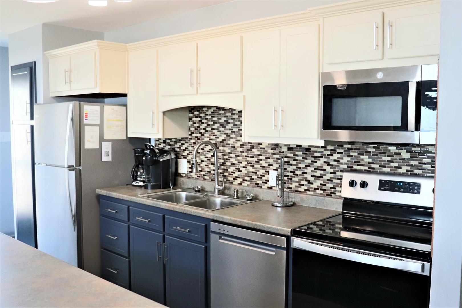 Your fully equipped kitchen features stainless steel appliances, elegant mosaic backsplash, and ample counter space for cooking memorable vacation meals.