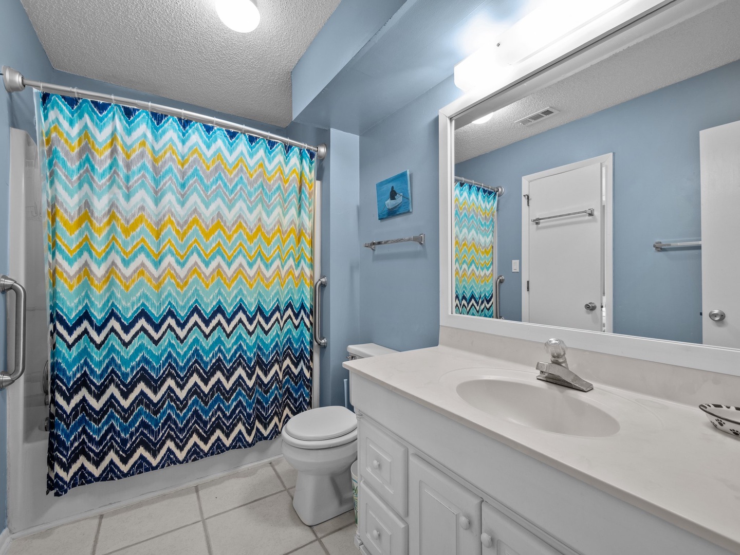 Refresh in your bright bathroom featuring a cheerful chevron shower curtain and plenty of counter space for your essentials.