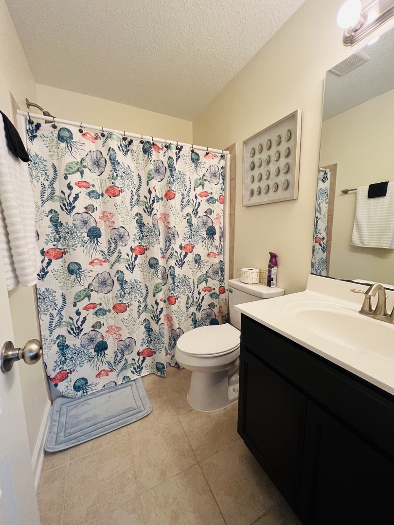 Refresh in your private bathroom with coastal charm—featuring ocean-themed decor and modern amenities for a delightful getaway experience.