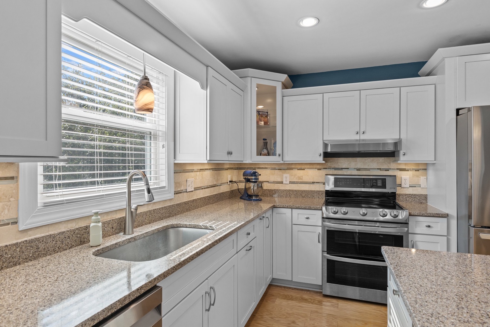 Your fully equipped kitchen features granite countertops, stainless steel appliances, and bright natural light for preparing memorable meals.
