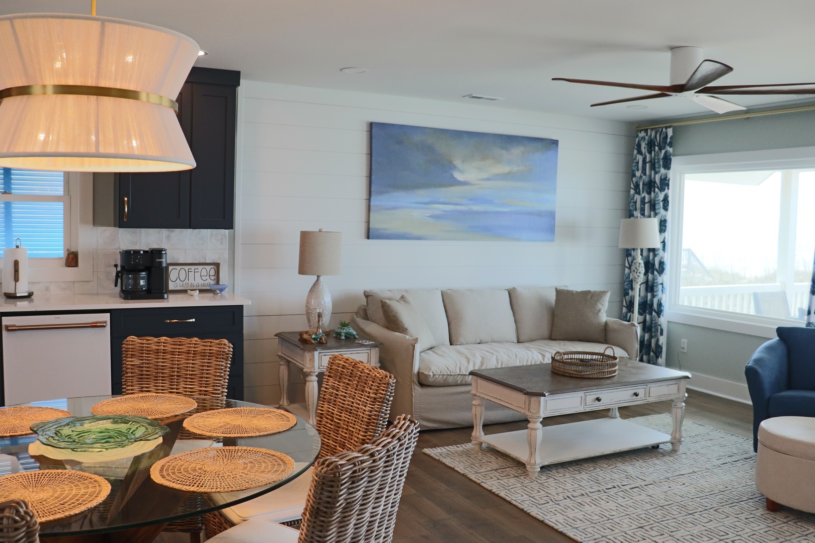 Relax in your coastal-inspired living space where ocean artwork and natural textures create the perfect beach getaway atmosphere.