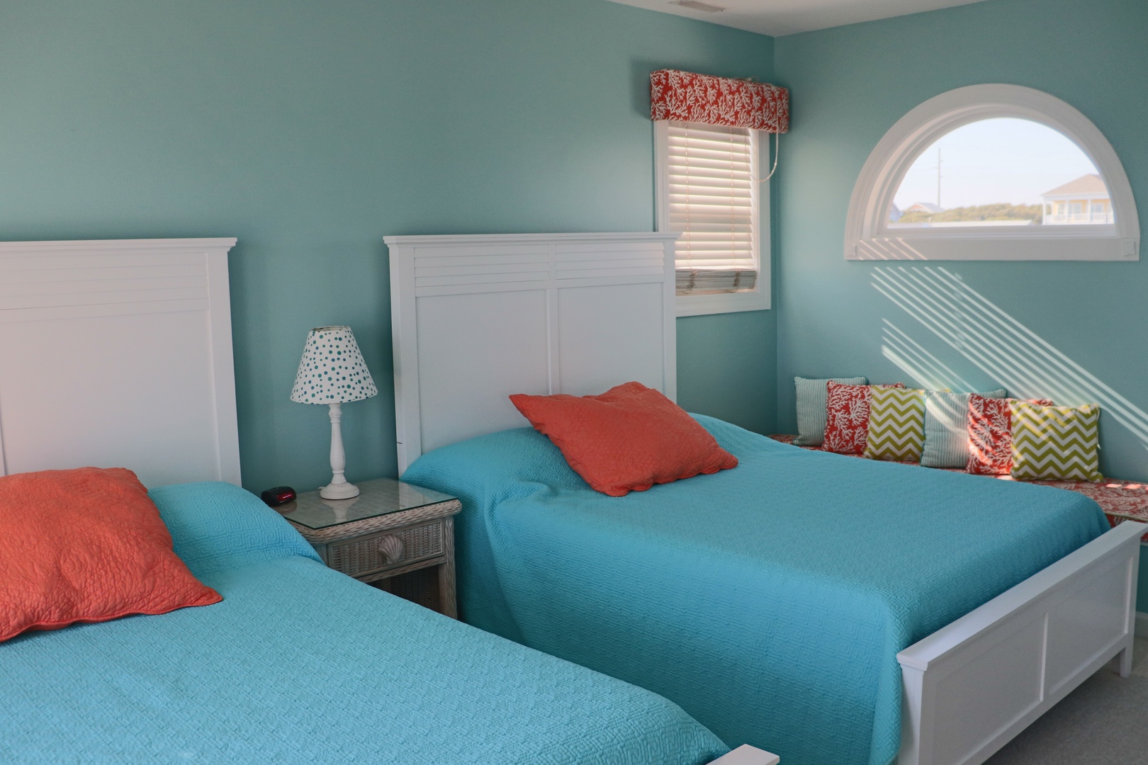 Wake up refreshed in this cheerful twin bedroom with turquoise walls and bright coral accents that create your perfect coastal retreat.