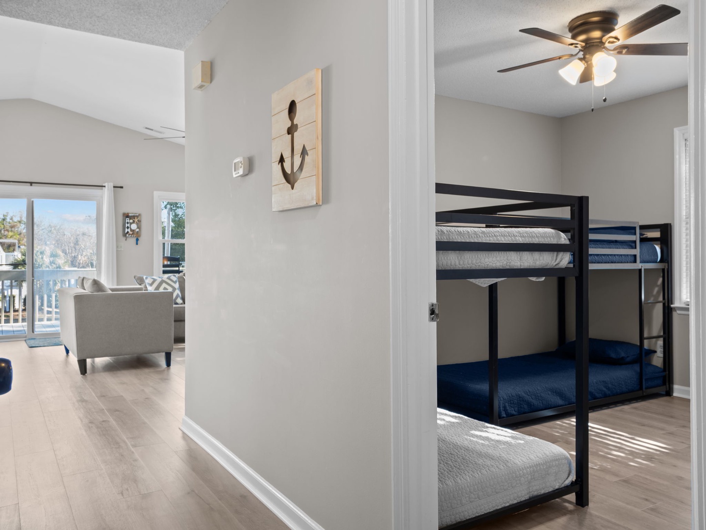 Your bunk bed nook offers cozy sleeping quarters with navy bedding, while the open layout flows into the bright living area.