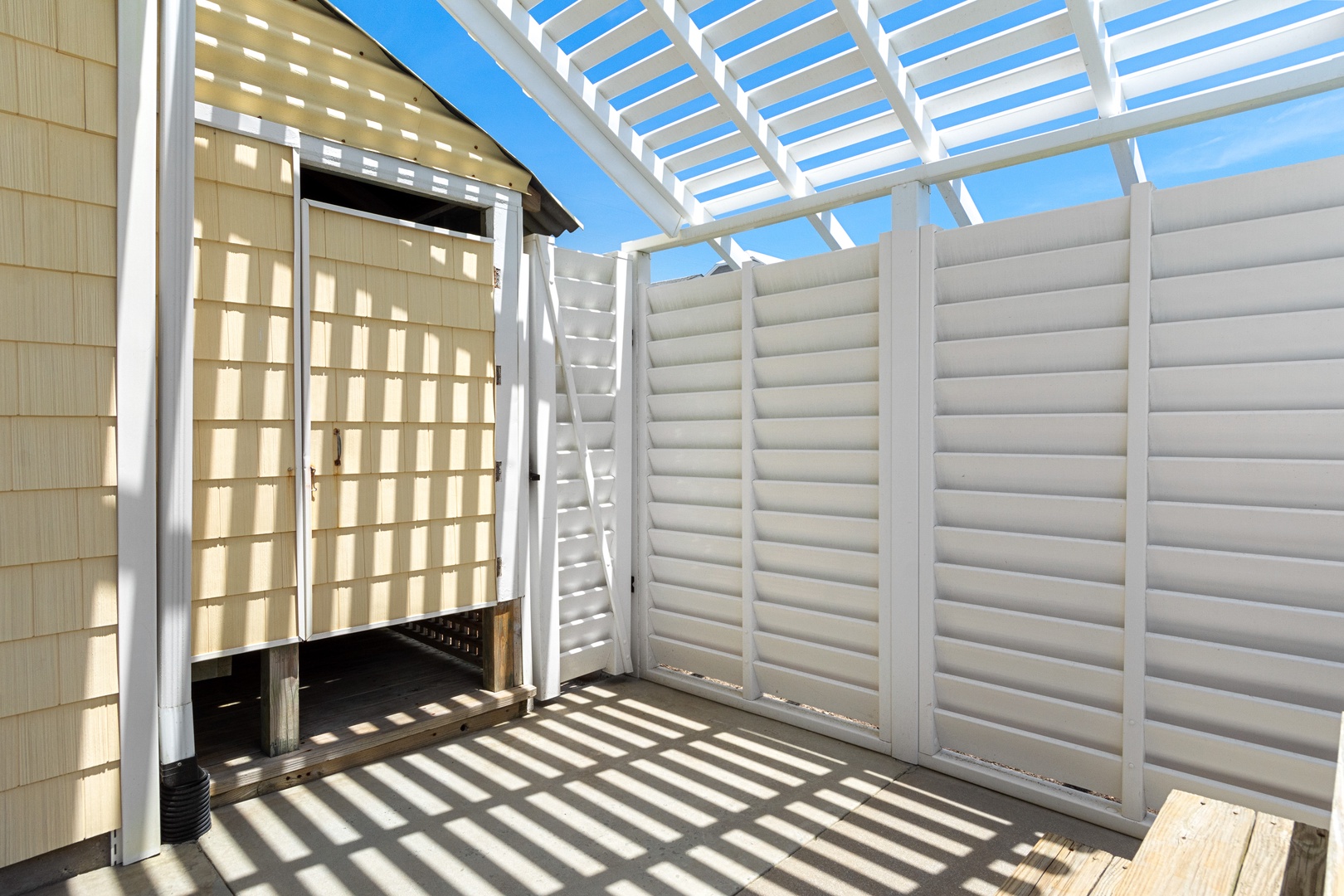 Your private outdoor shower awaits, surrounded by elegant privacy screens that create beautiful shadow patterns while you refresh.