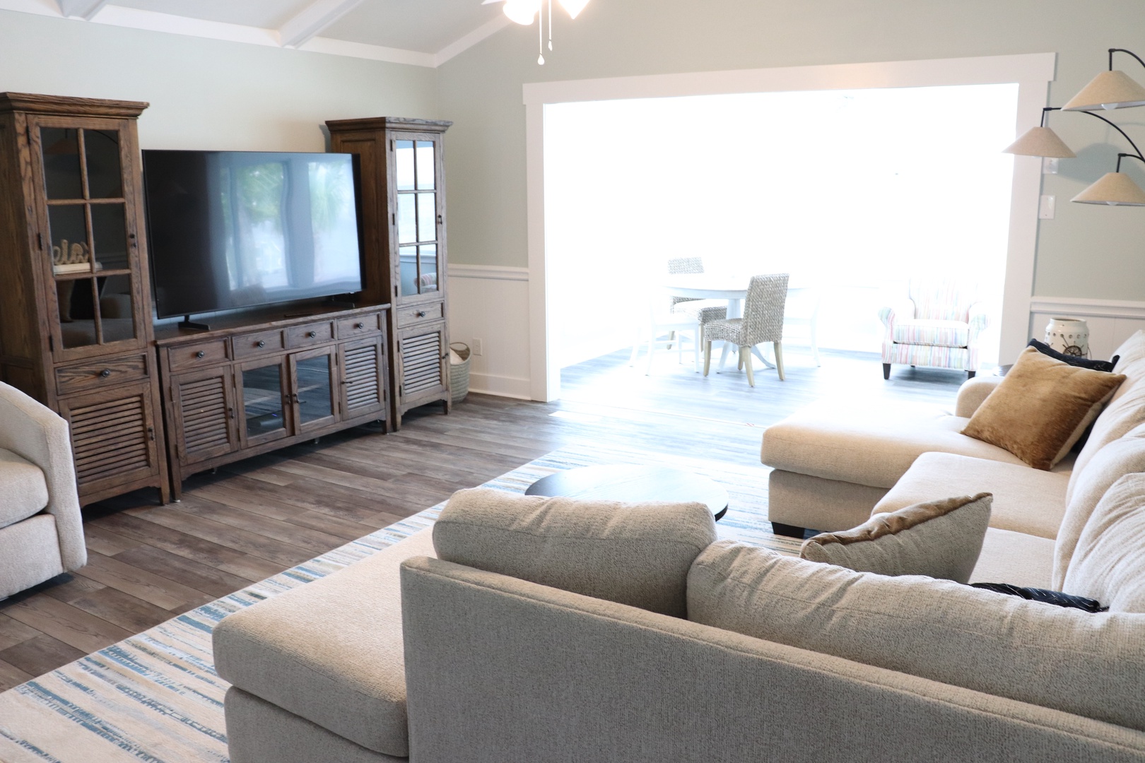 Unwind in this bright living room with plush seating, entertainment center, and sunny space for relaxation.