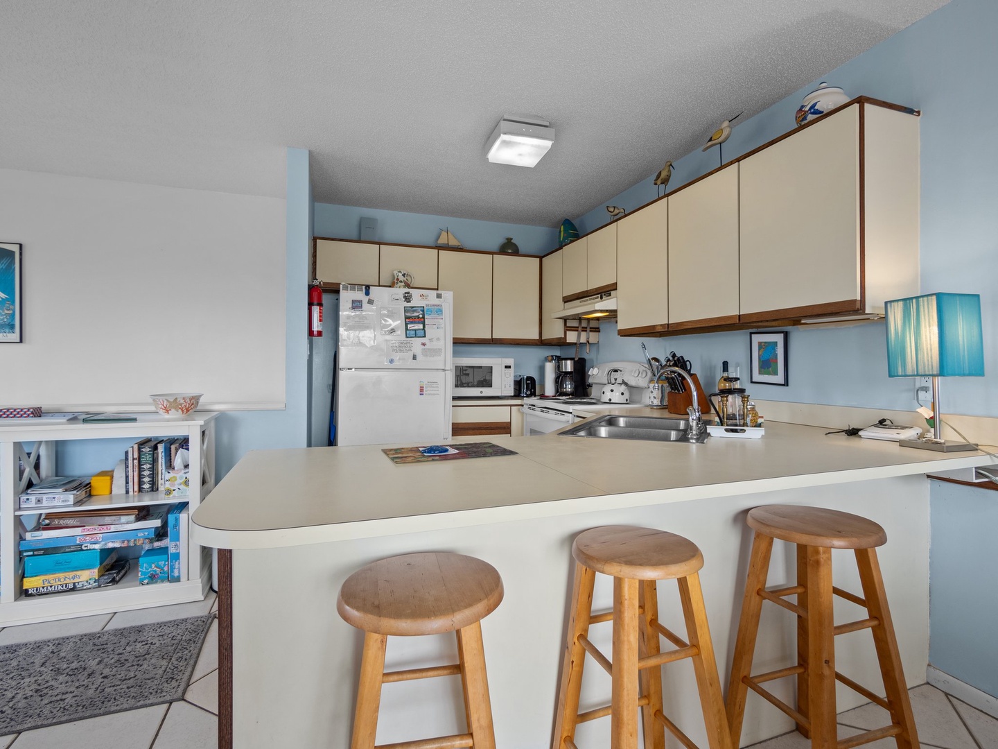 Your fully equipped kitchen awaits with everything needed to prepare meals, featuring a breakfast bar perfect for morning coffee.