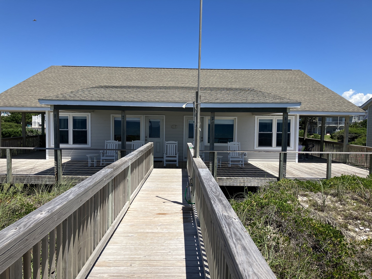 Beachfront cottage with private boardwalk leading directly to the front entrance through coastal dunes.