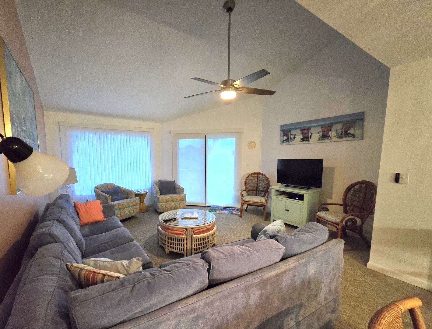 Unwind in your spacious living room with plush seating, entertainment center, and gentle ceiling fan creating the perfect atmosphere for relaxation.