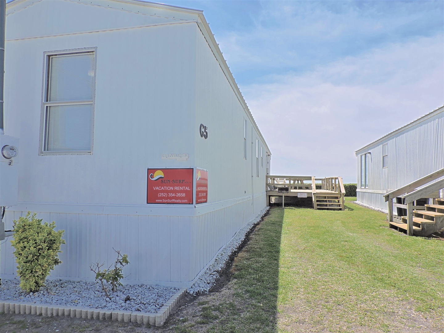 Vacation rental unit C5 sits in a quiet residential community with manicured landscaping and wooden deck access.