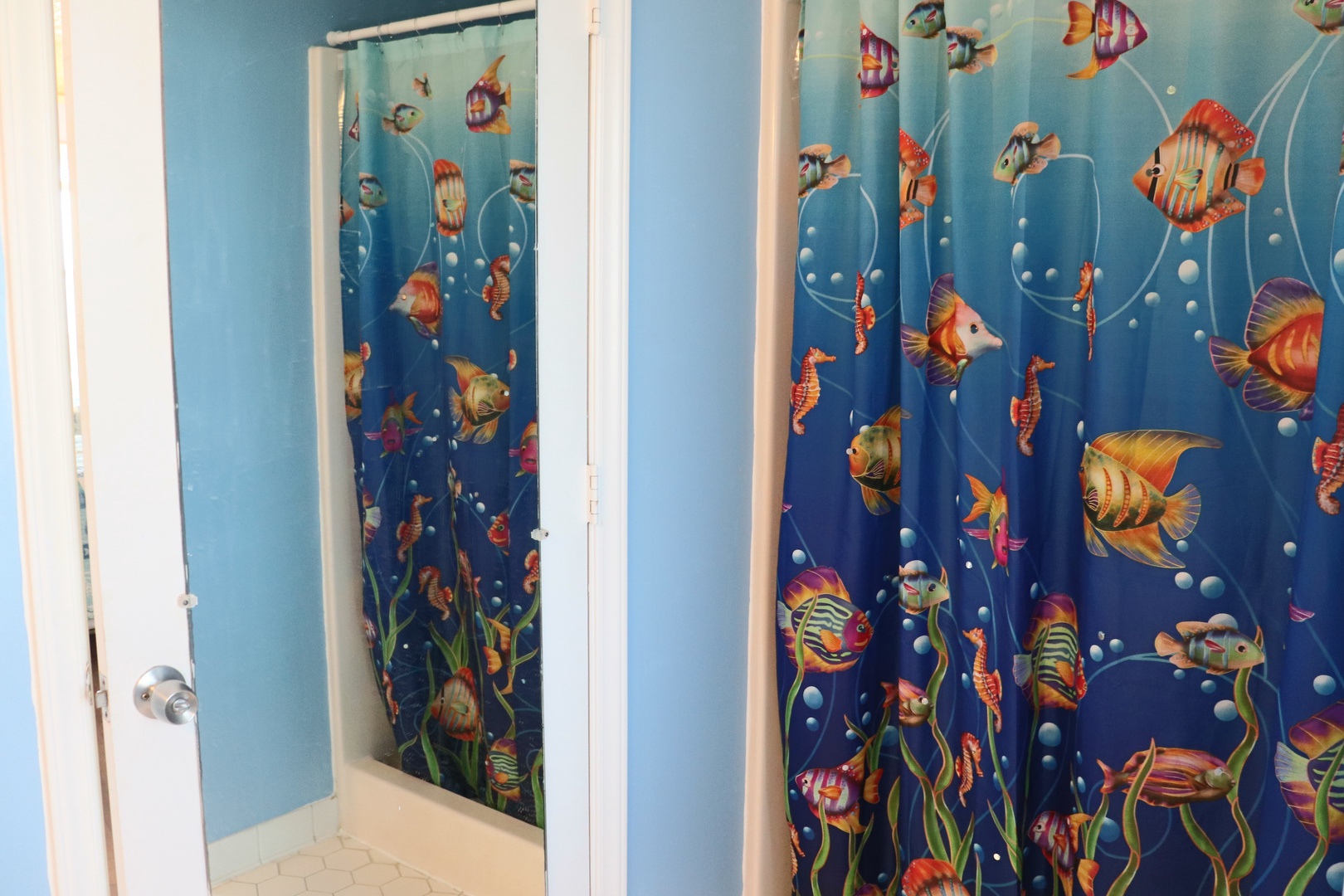 Step into your whimsical underwater bathroom where colorful tropical fish swim alongside seahorses and coral on the vibrant shower curtain.