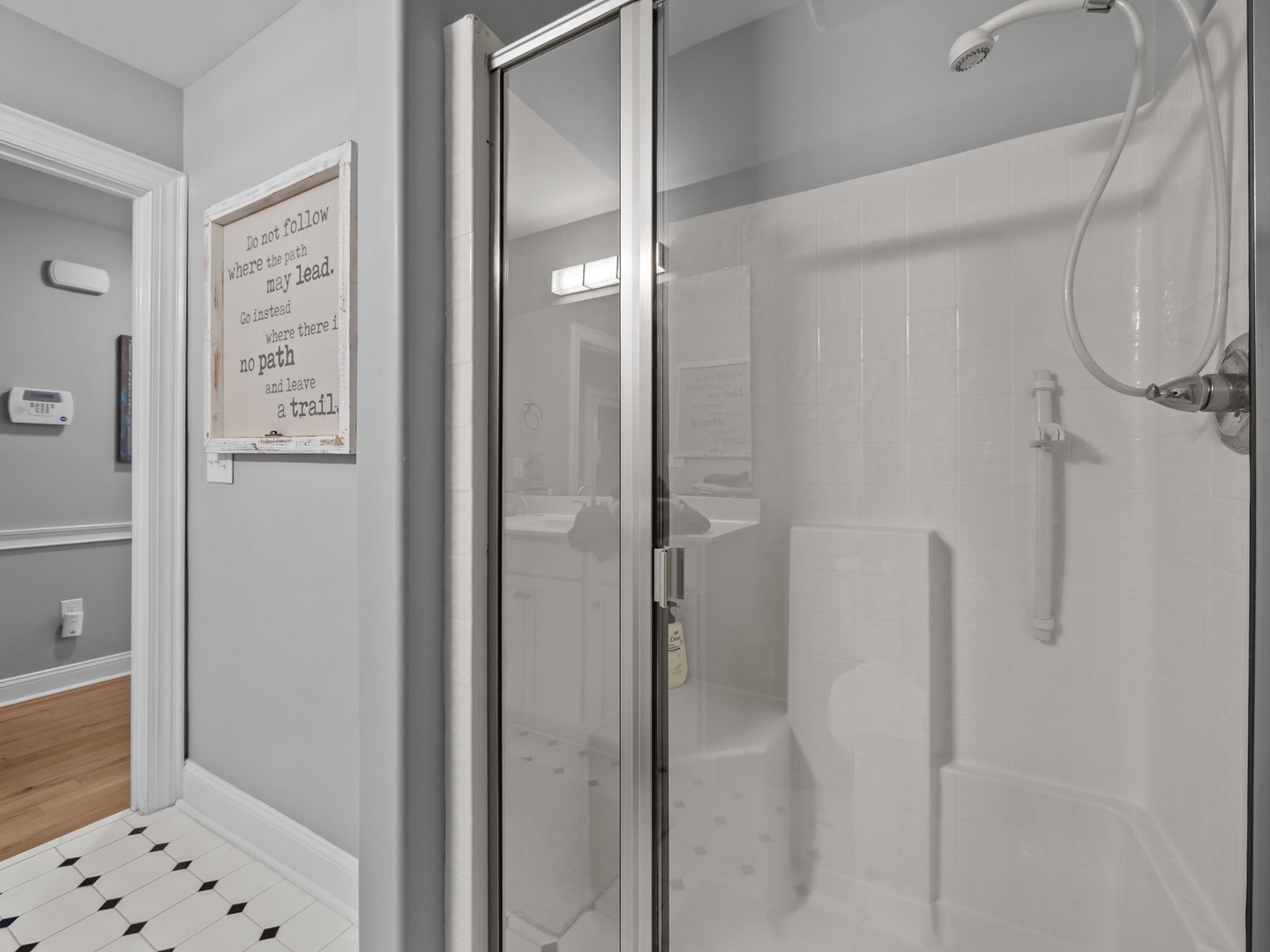 Step into your pristine private shower with gleaming glass doors and rainfall showerhead for a refreshing start to your day.