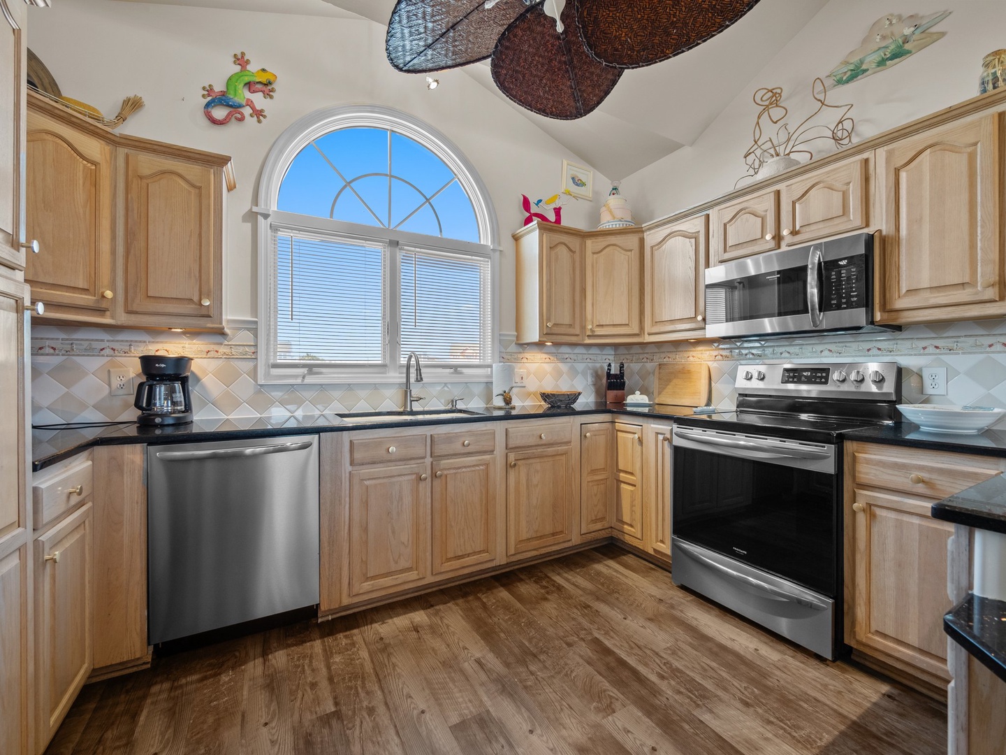 Your fully equipped kitchen invites culinary adventures with warm wood cabinets, granite counters, and stainless appliances bathed in natural light.