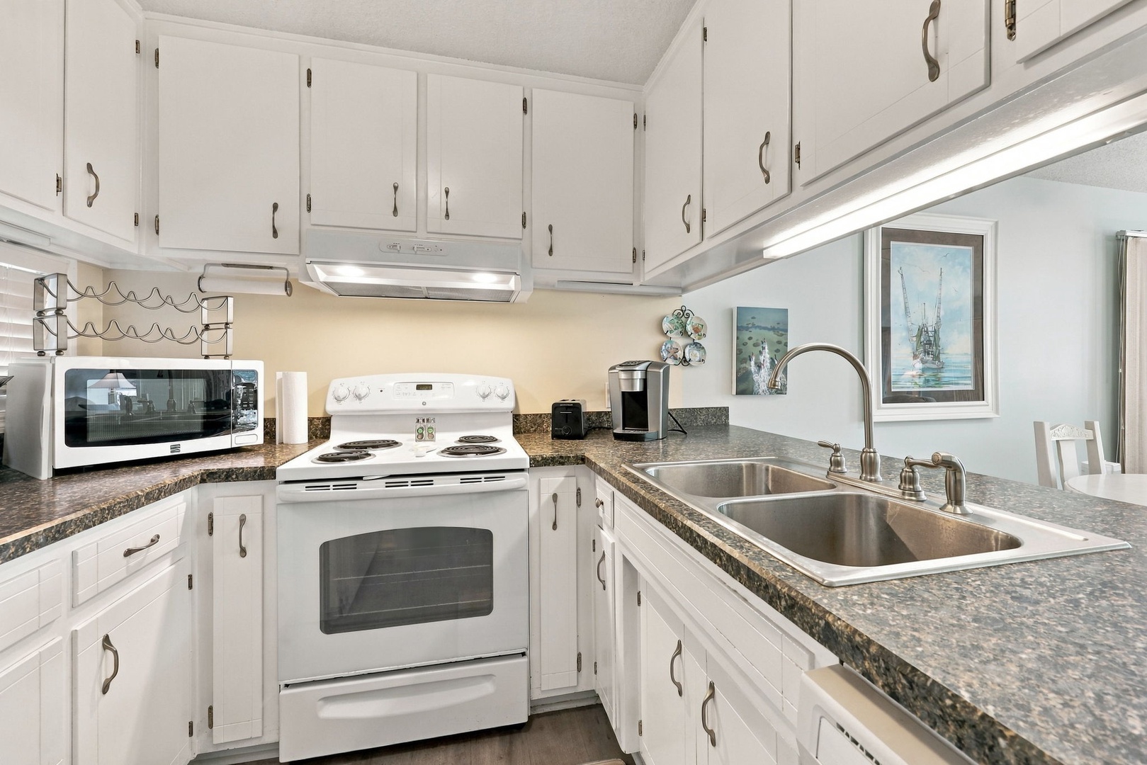 Cook your favorite meals in this bright, fully-equipped kitchen with everything you need for a comfortable stay, from the microwave and stove to ample counter space and storage.