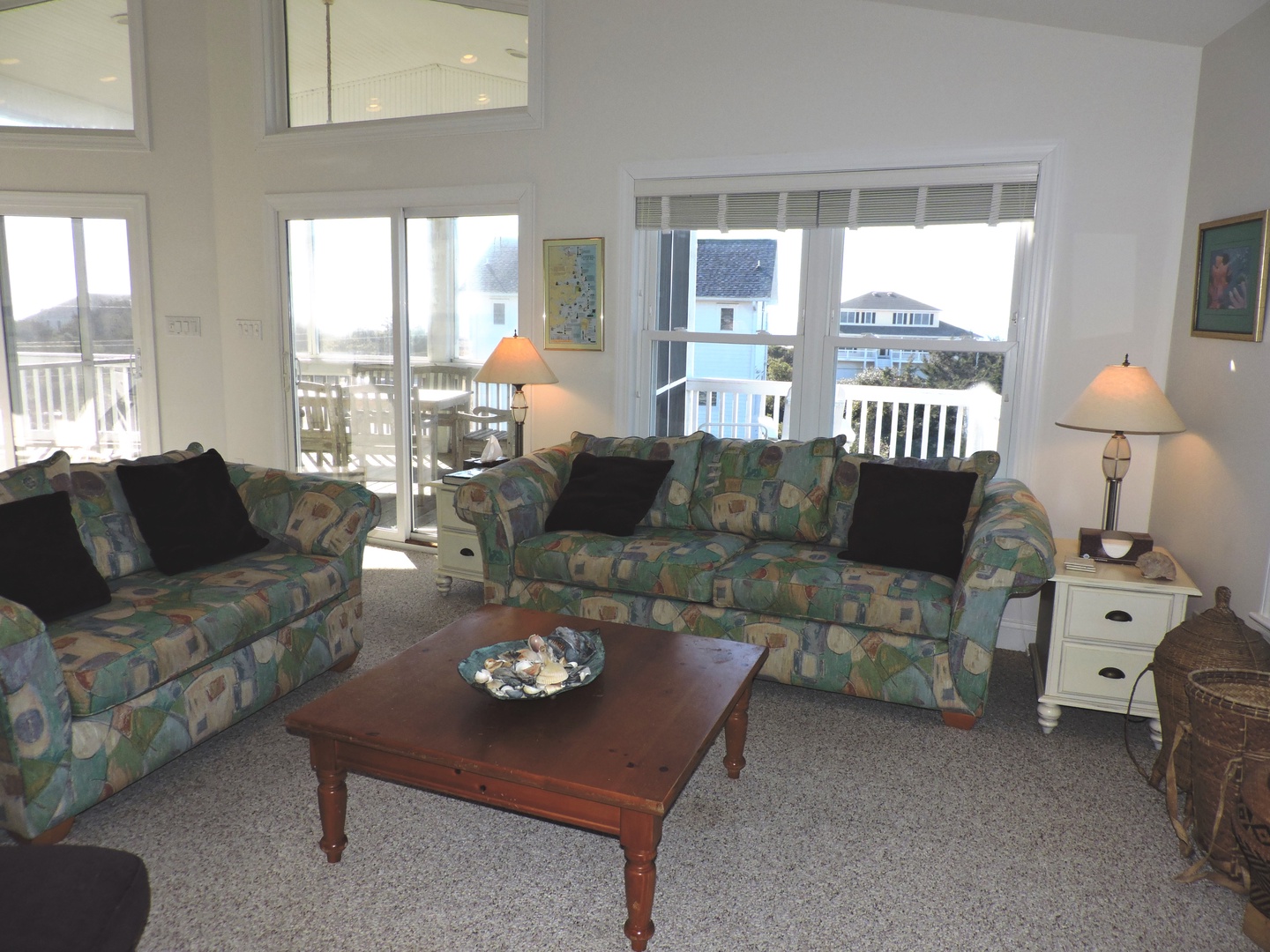 Unwind in your bright living room with cozy patterned sofas and ocean glimpses through large windows—your perfect coastal retreat.