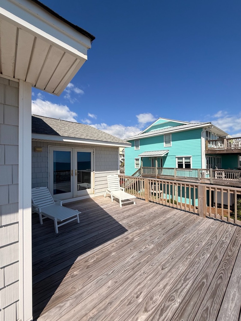 A spacious private deck where you can lounge under coastal blue skies, soaking up the sun and fresh ocean breeze just steps from your door.