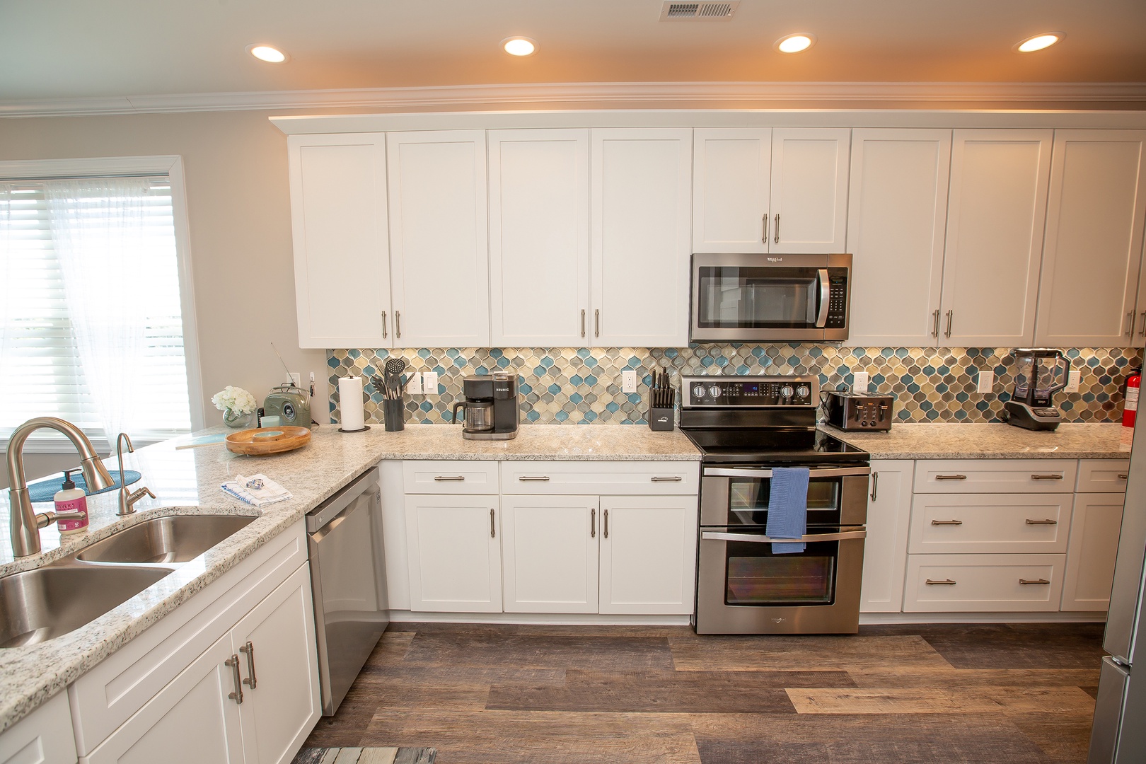 Your fully equipped kitchen features granite counters, stainless appliances, and a stunning mosaic backsplash for memorable meal prep.