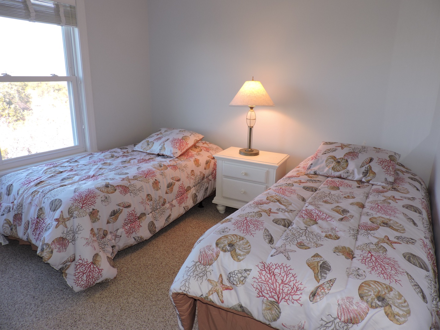 Sleep peacefully in your coastal-themed twin bedroom, where ocean-inspired linens and warm lamplight create the perfect seaside retreat for restful nights.