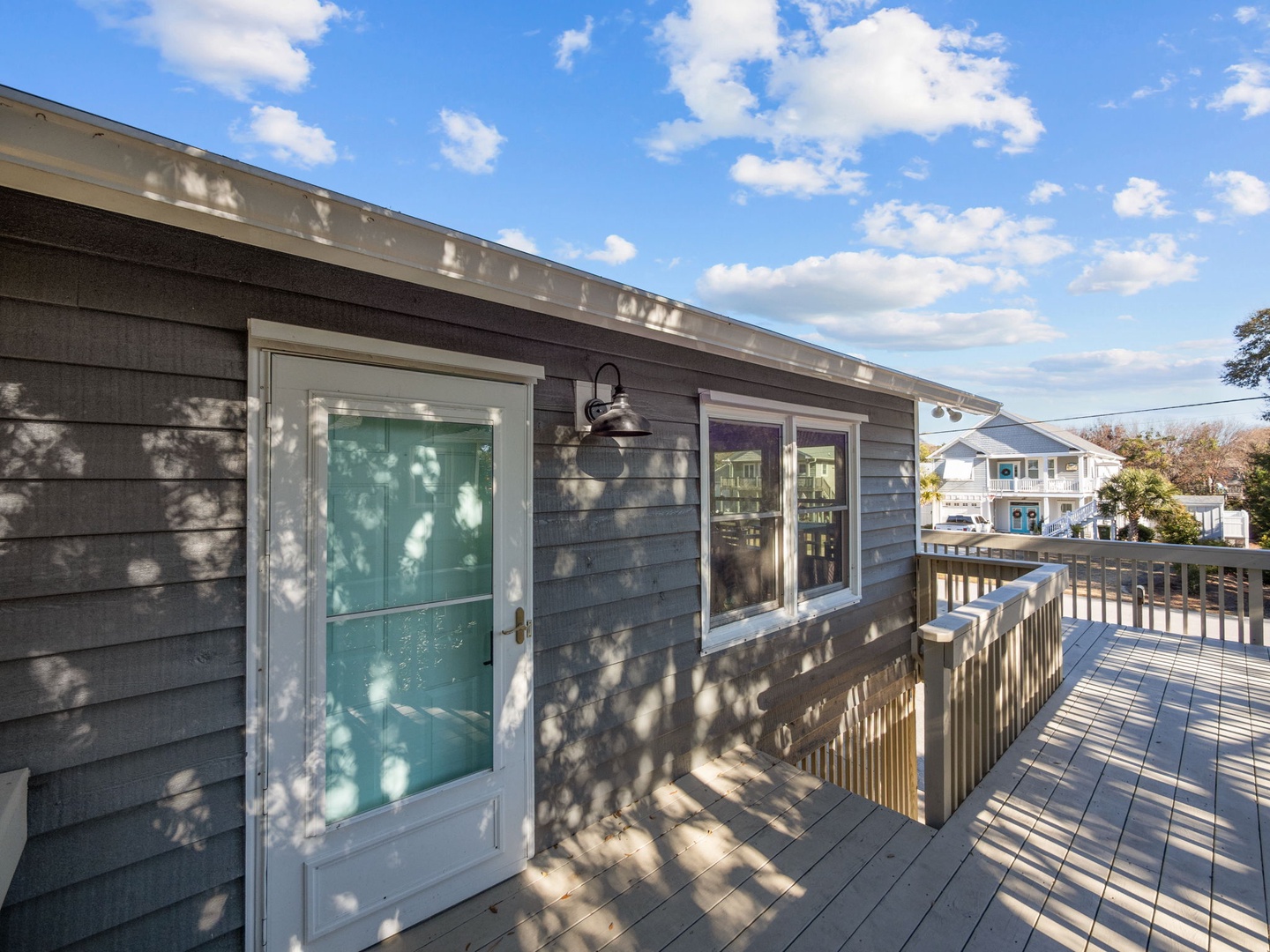 Step onto your private deck where coastal charm meets comfort, surrounded by neighboring homes in this peaceful residential setting.