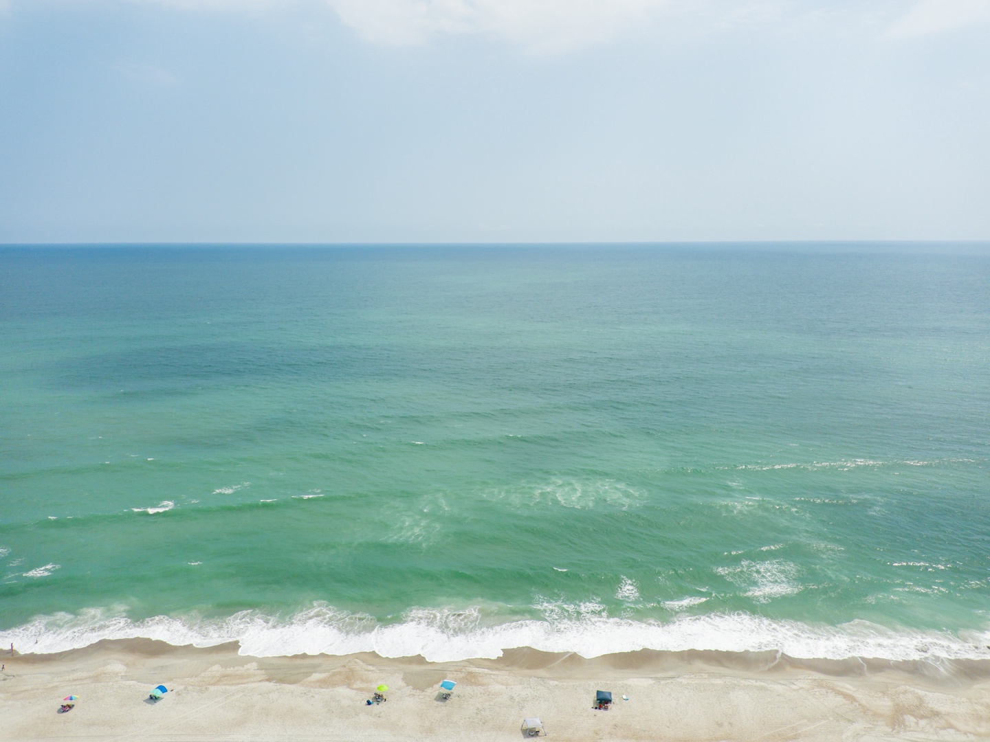 Pristine coastline with turquoise waters stretching to the horizon, offering beachfront relaxation steps from the property.