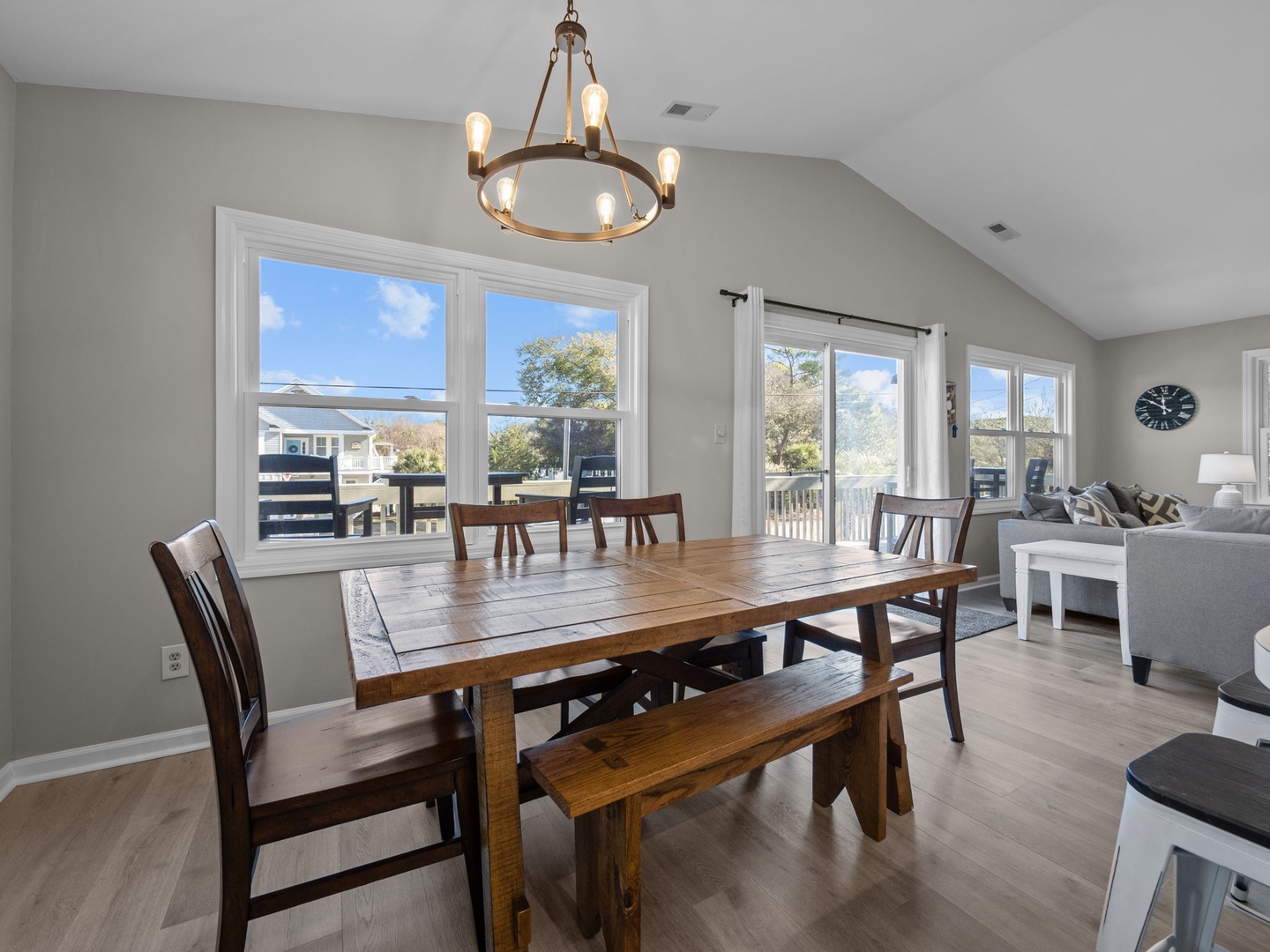Gather around this inviting rustic dining table where you'll share memorable meals together, all while enjoying natural light streaming through expansive windows.