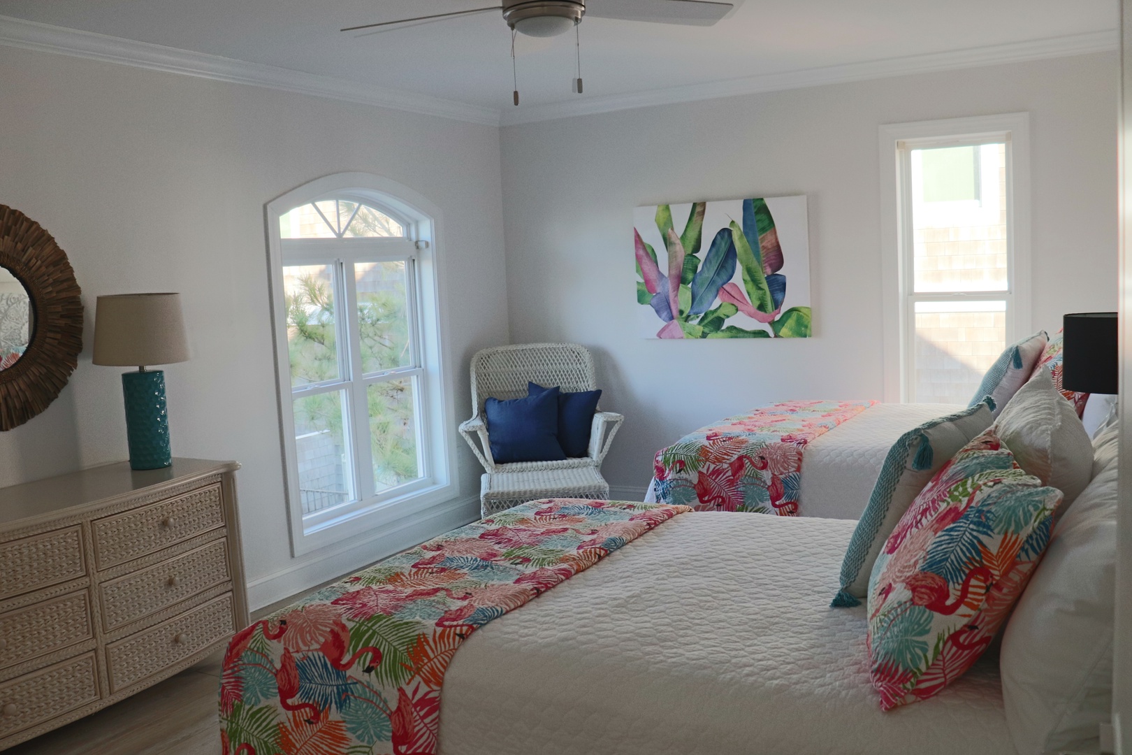 Drift off to sleep in this bright tropical-themed bedroom with twin beds, colorful linens, and cheerful artwork to brighten your mornings.