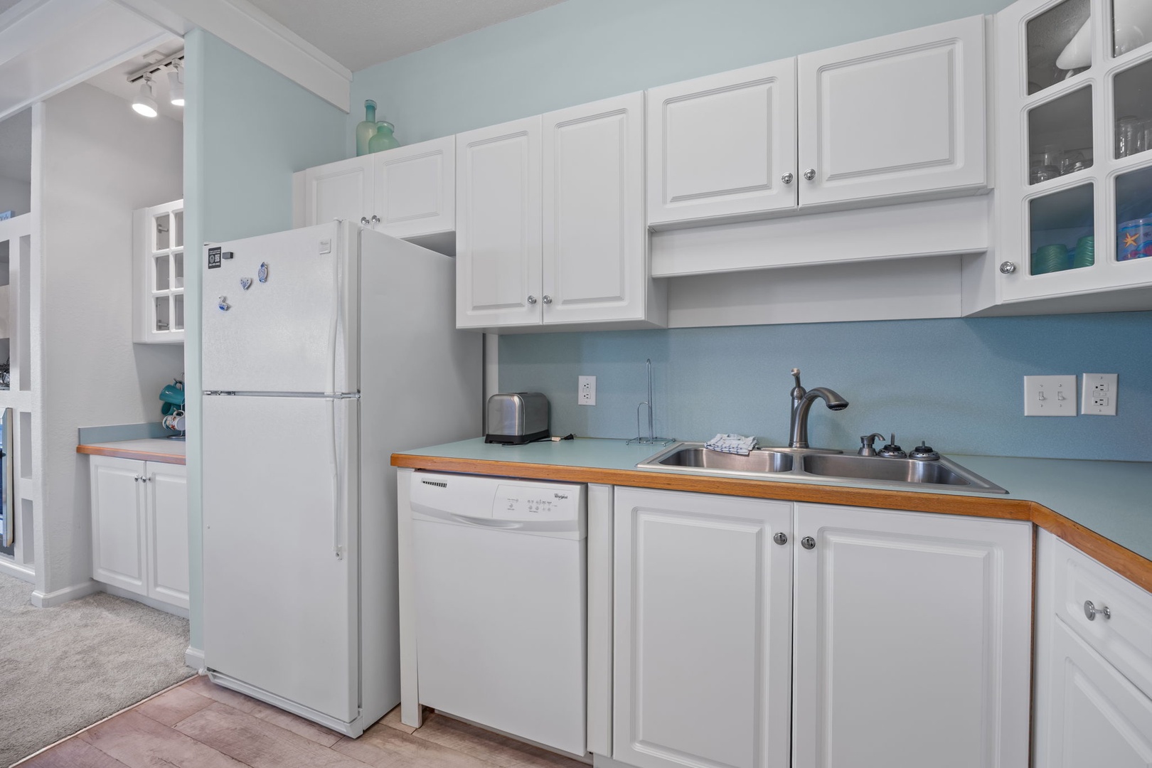 Your bright, fully-equipped kitchen invites home cooking with all appliances, ample cabinet storage, and calming coastal colors.