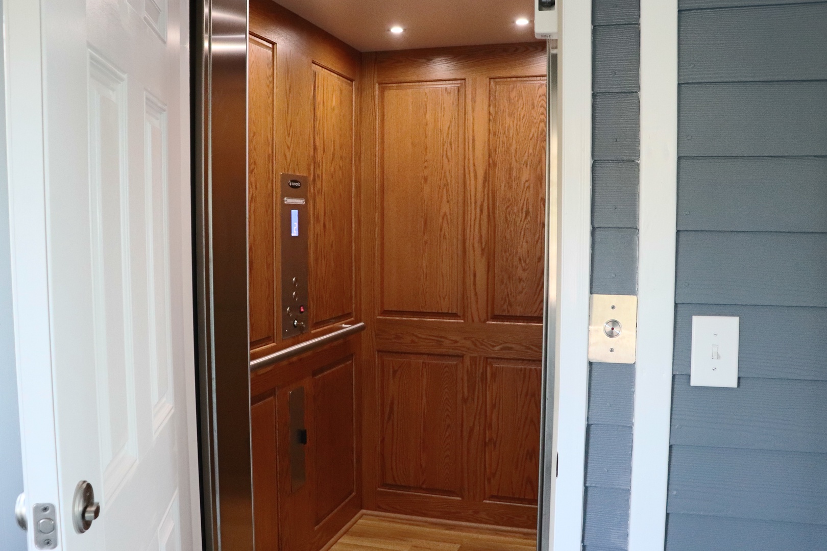 Step into your private elevator with elegant wood paneling and modern convenience at your fingertips.
