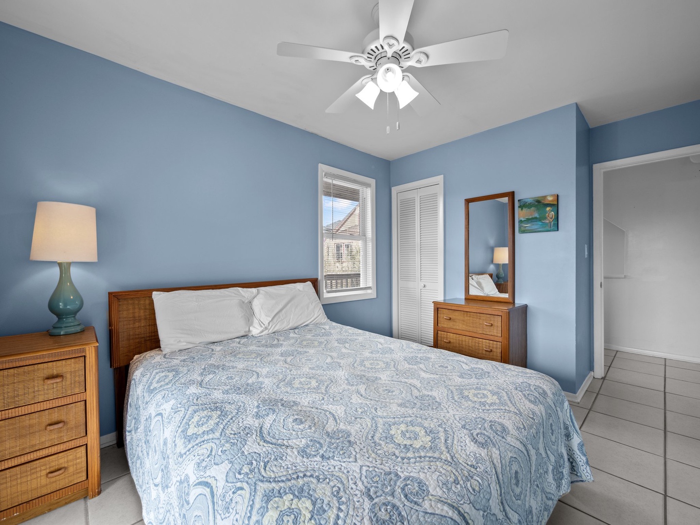 Unwind in your serene bedroom with soft blue walls, comfy queen bed, and tropical breezes from your ceiling fan.