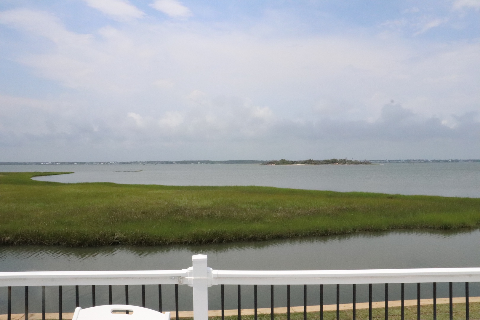 Peaceful waterfront views stretch across calm waters and green marshlands from this tranquil property location.