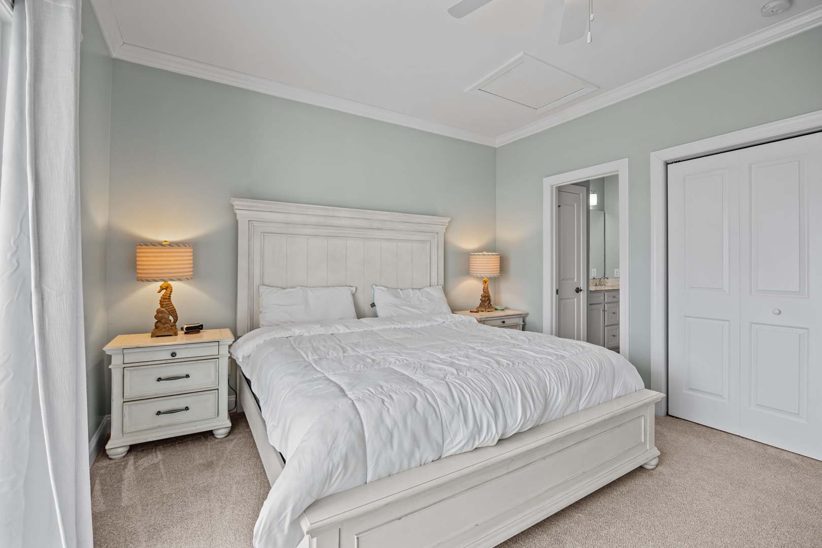 Drift off to sleep in this serene bedroom with its plush king bed, soft linens, and soothing sage walls that create your perfect retreat.