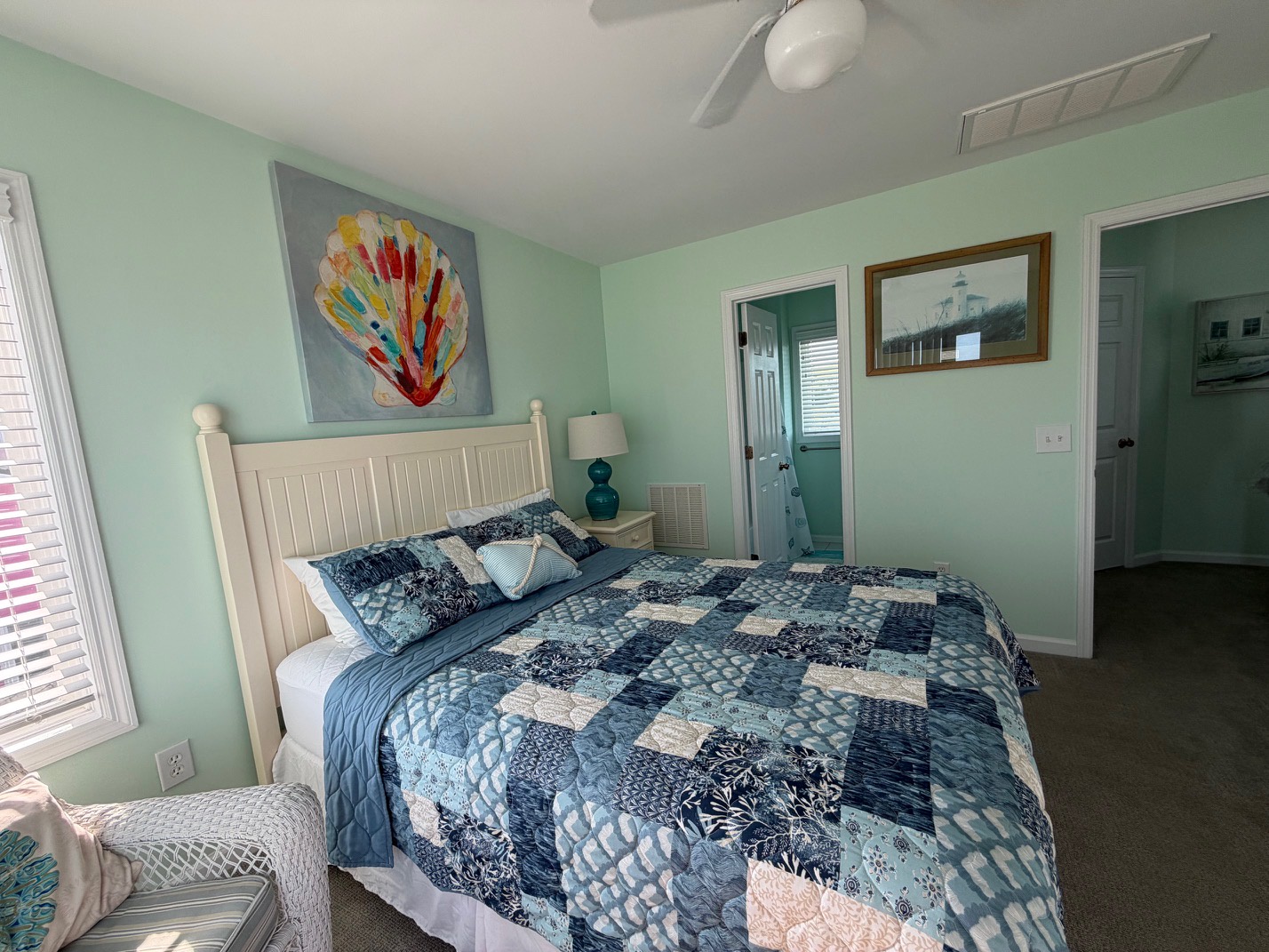 Drift off to sleep in this coastal-inspired bedroom with soothing mint walls and ocean-themed artwork creating your perfect seaside retreat.