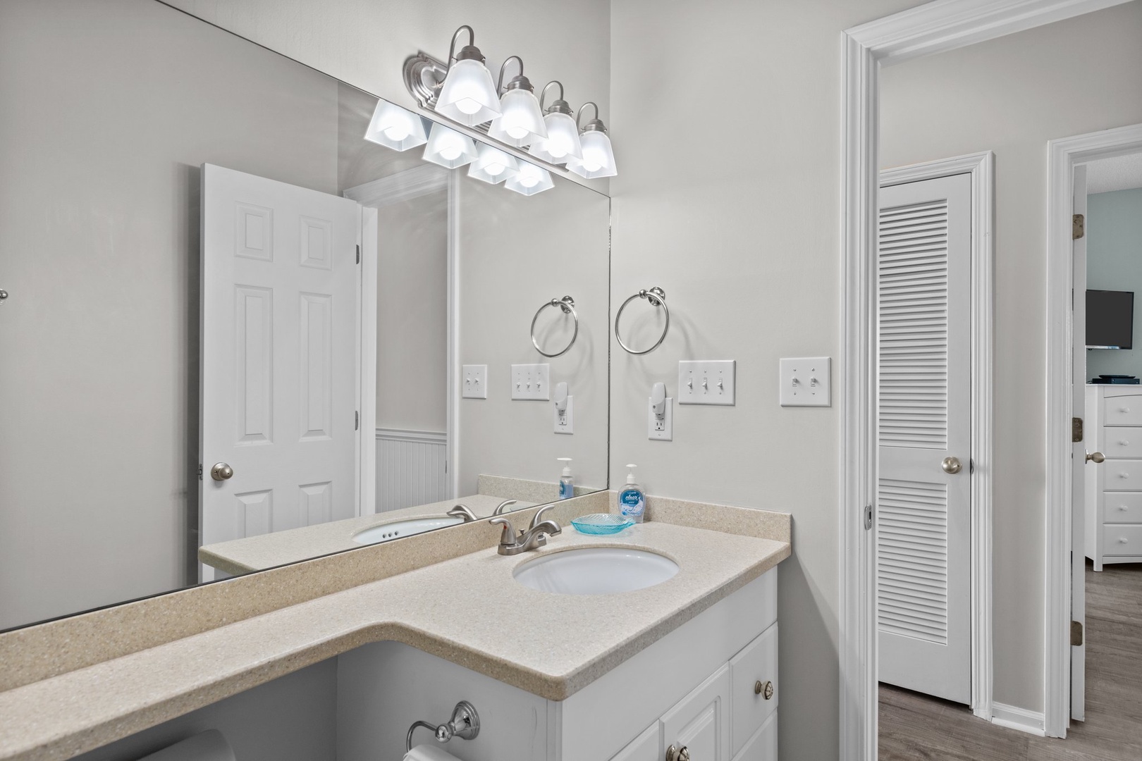Step into your bright, spacious bathroom with dual vanities and crisp white finishes for your morning routine.