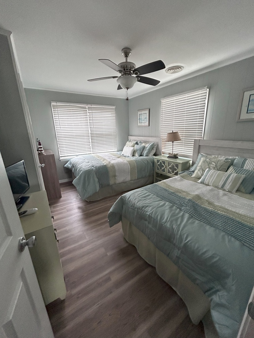 Drift off peacefully in your serene bedroom featuring twin beds dressed in calming coastal linens and gentle natural light.
