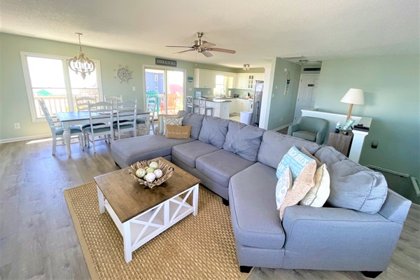 Relax in your spacious open-plan living area, where coastal comfort meets modern convenience with a full kitchen and dining space for memorable meals.