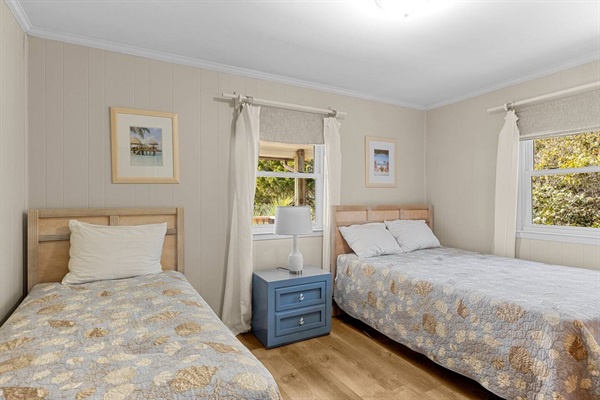 Drift off to peaceful sleep in this bright, airy bedroom with twin beds and charming coastal artwork adorning the walls.