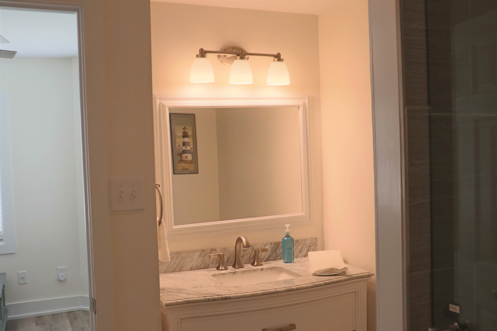 Unwind in your elegant bathroom featuring a marble vanity, perfect lighting, and thoughtful amenities for your comfort.