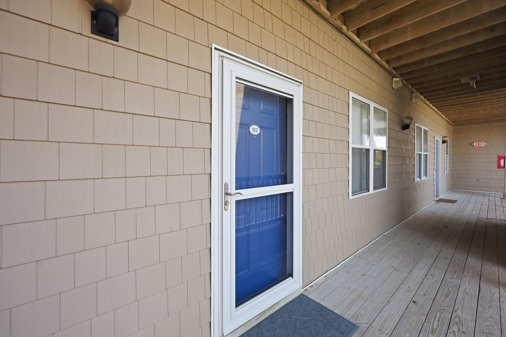 Exterior walkway featuring private entryways and a covered breezeway connecting individual units at this beachside property.