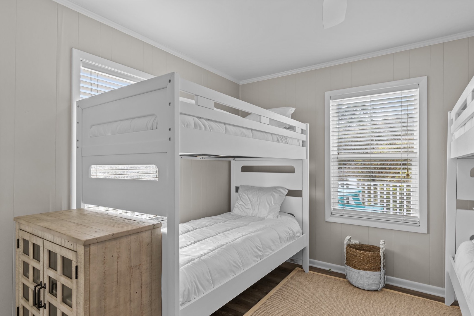 Your cozy bunk room features crisp white linens and coastal charm, perfect for kids or extra guests to drift off peacefully.