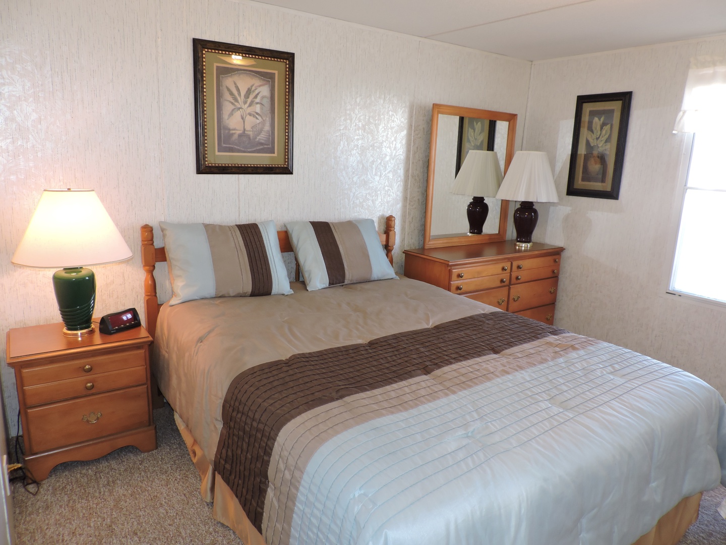 Unwind in your cozy bedroom with plush bedding, warm lighting, and classic tropical artwork creating the perfect restful retreat.