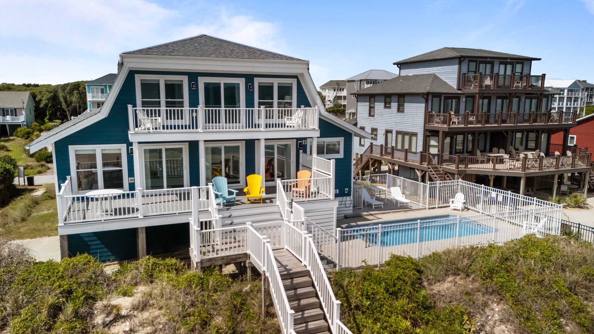 Charming coastal retreat with private pool and expansive decking overlooking the shoreline community.