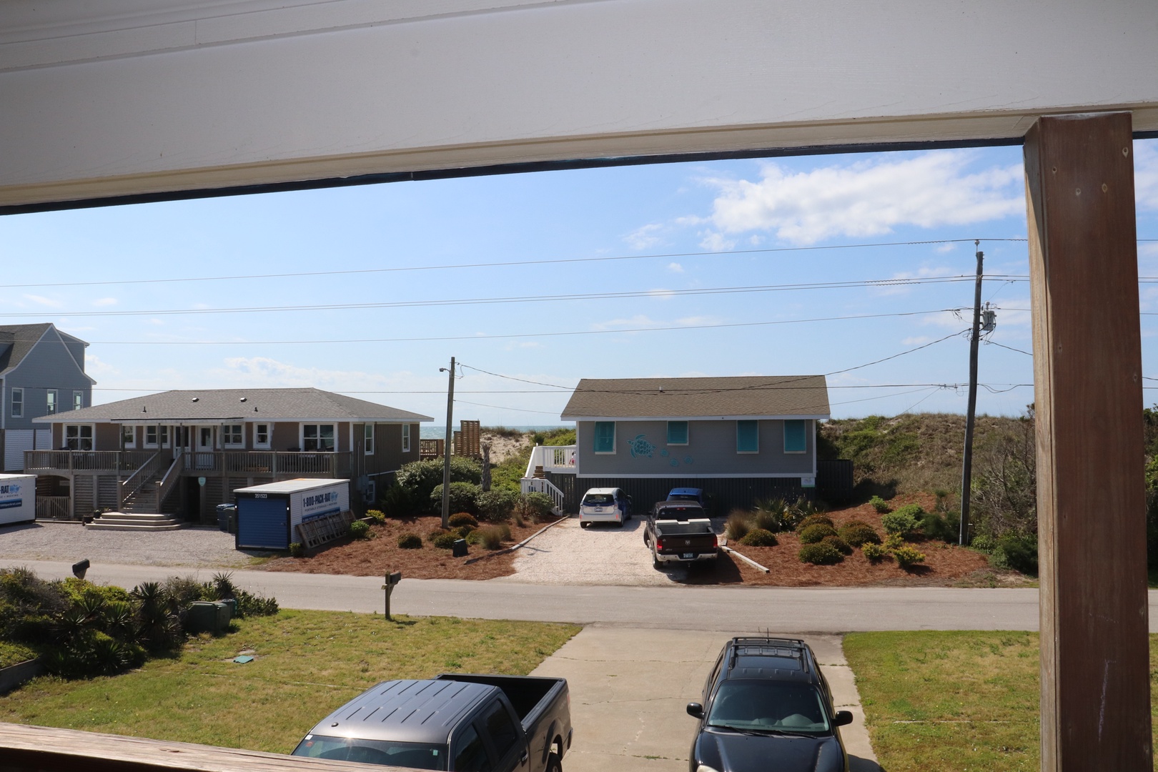 Watch the neighborhood come to life from your covered porch, where coastal homes and blue skies create a perfect backdrop for your morning coffee.