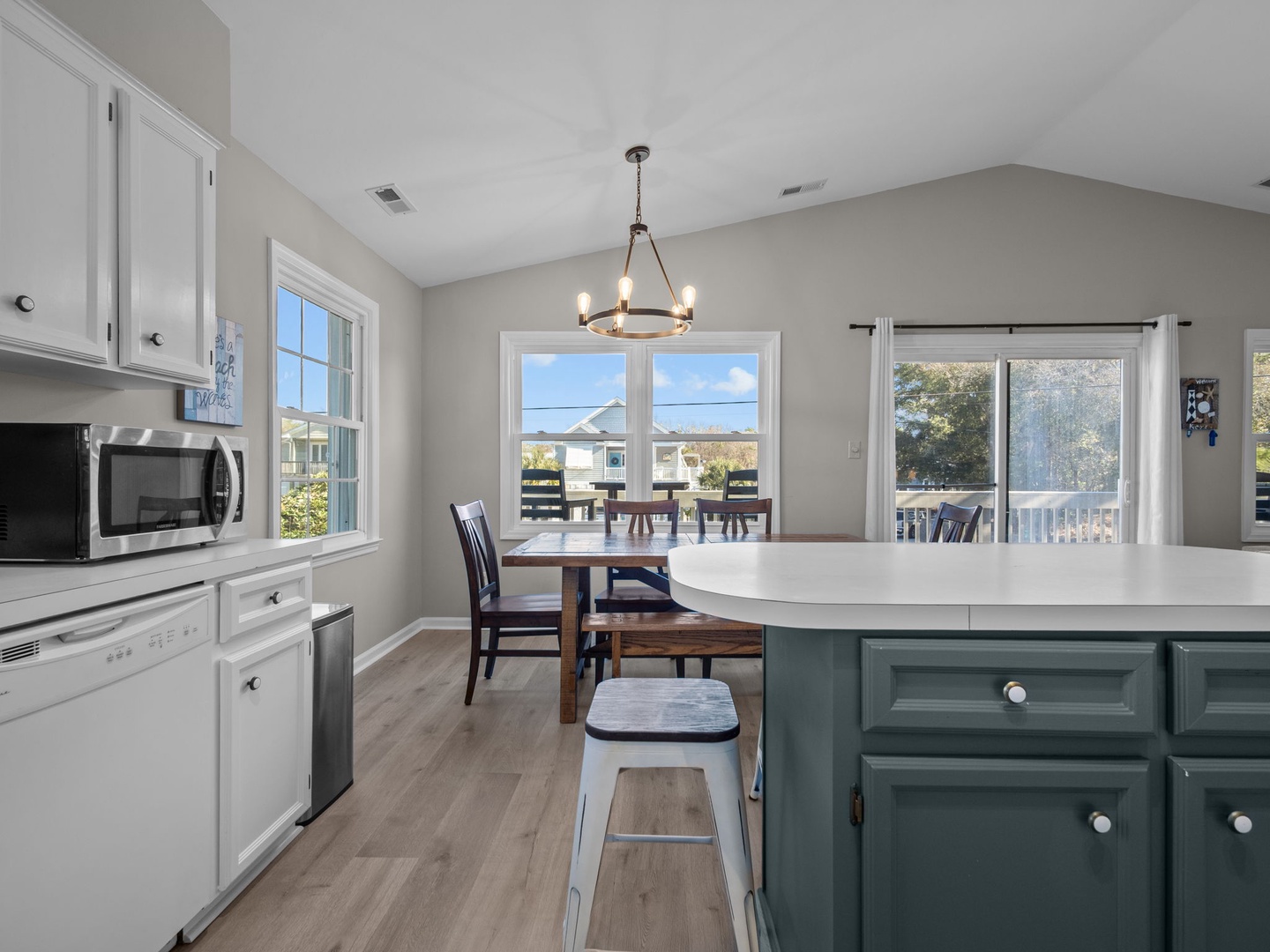 Your bright, open kitchen flows into dining space with natural light streaming through large windows and modern island seating.