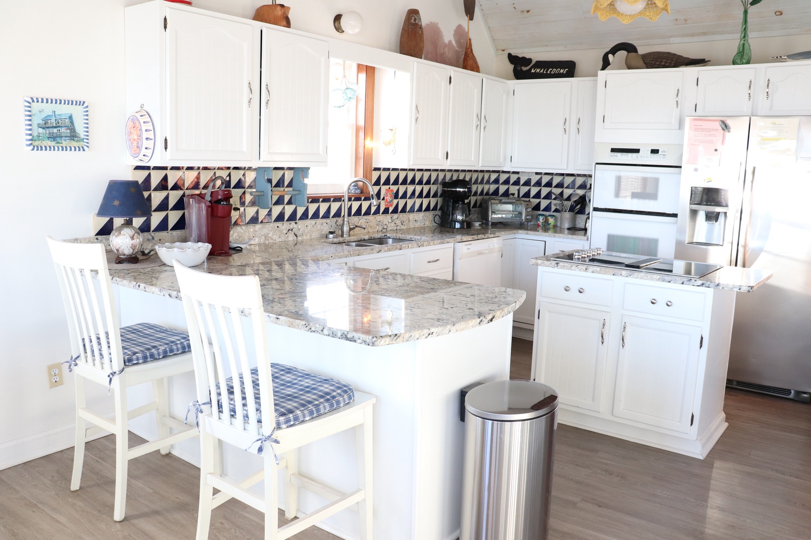 Your bright kitchen awaits with granite countertops, full appliances, and cheerful blue accents for memorable home-cooked meals.