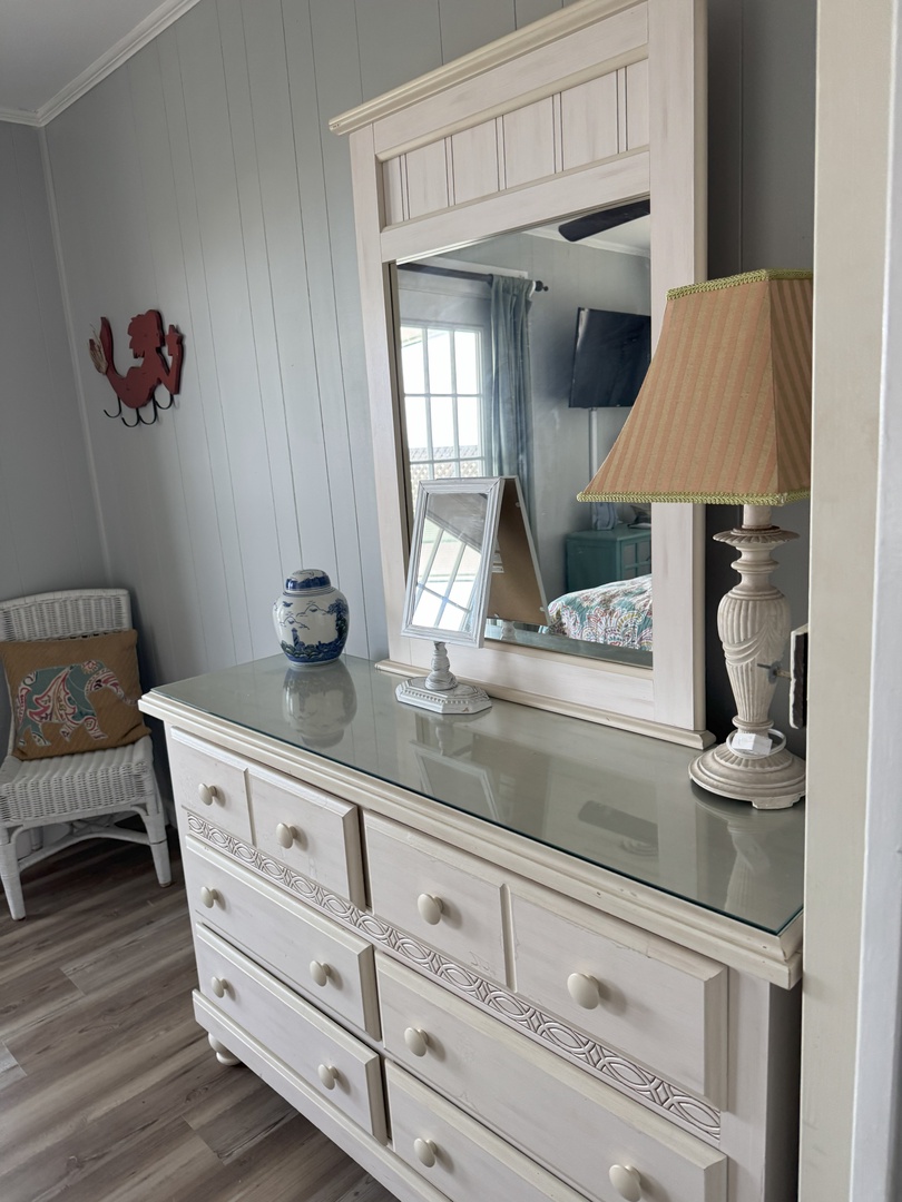Your elegant dresser creates a perfect spot for morning routines, with charming coastal touches and warm lighting to start each day.
