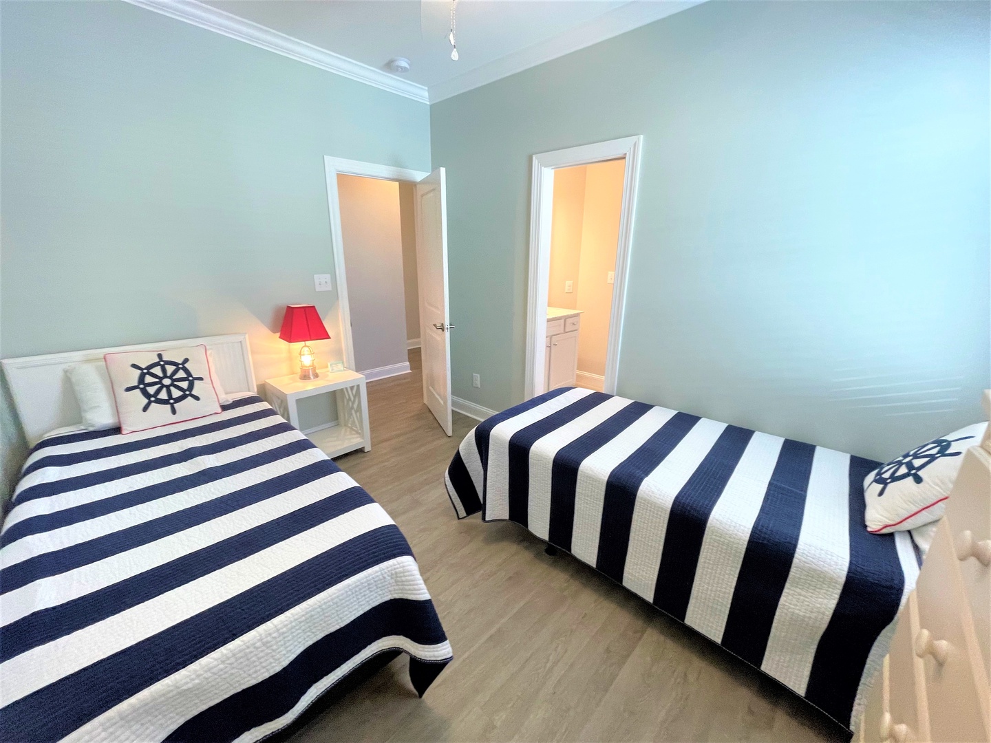 Drift off to sleep in your nautical-themed twin bedroom, where crisp navy stripes and sea-inspired decor create a peaceful coastal retreat.