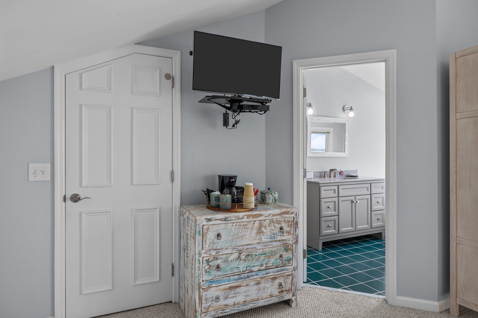 Enjoy your wall-mounted TV and convenient coffee station, with your private bathroom featuring beautiful teal tile just steps away.