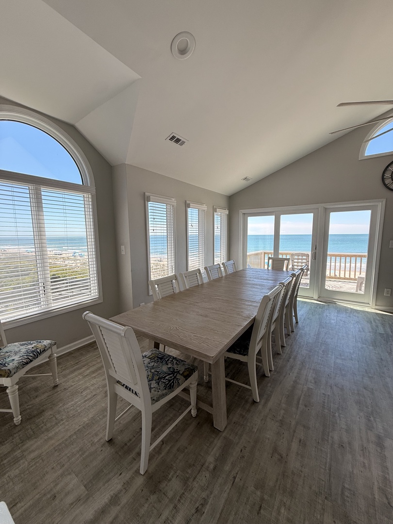 Sink into soft seating beside soaring windows framing ocean glimpses, where natural light and breezy coastal views create your perfect retreat for morning coffee or unwinding after a day of adventure.