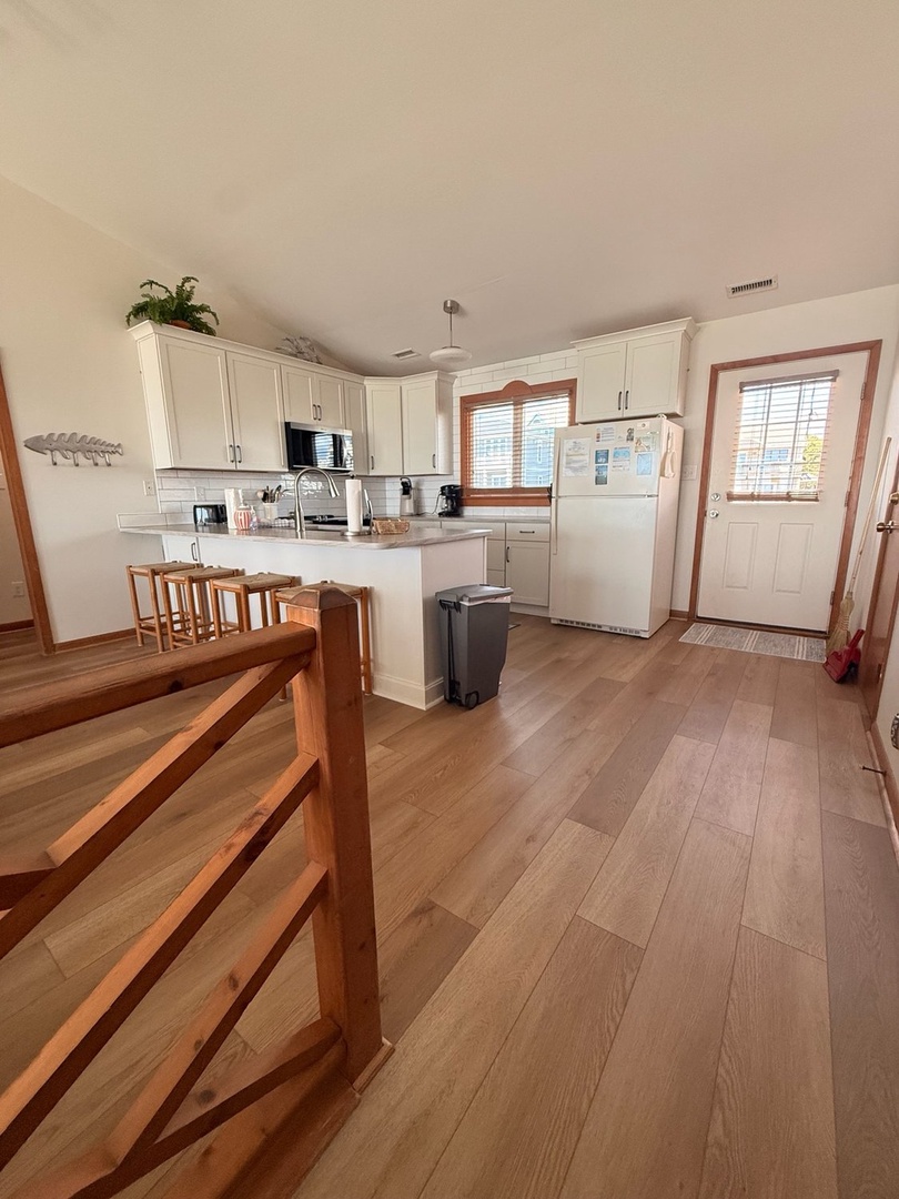 Step into your bright, fully equipped kitchen with crisp white cabinetry, warm wood accents, and everything you need to whip up meals together. Natural light pours in, making meal prep feel easy and inviting.