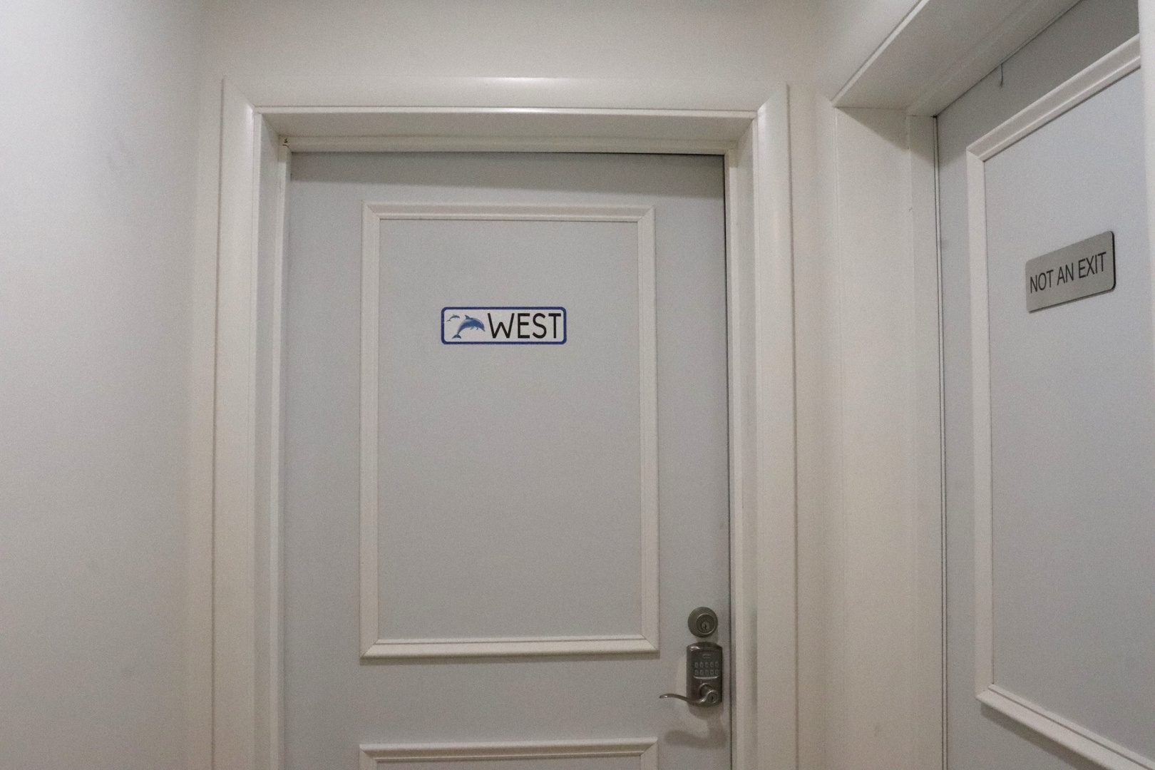 Interior hallway features a clean, modern design with directional signage and elevator access for convenient navigation throughout the property.